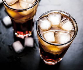 cola with ice on a wooden background. soft drinks