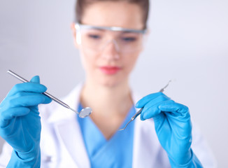 Attractive female dentist with tools , standing on gay