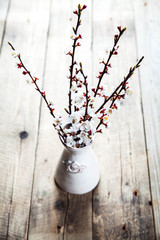 spring blossoms in vintage vase on wooden surface