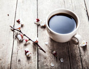 Cherry blossoms on a wooden background with a cup of coffee
