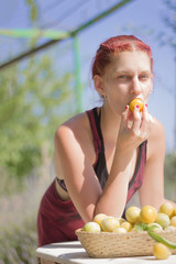 Young woman biting a plum