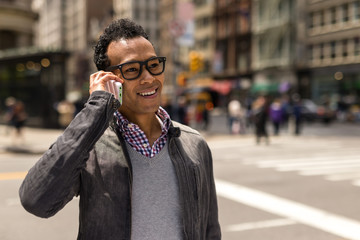Fototapeta premium Young African Asian man in New York City talking on cell phone