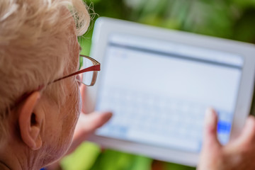 Senior woman using tablet, indoor