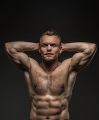 Fototapeta premium Muscular man posing in studio on grey background