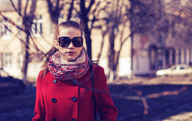 The girl in sunglasses walks around the city.