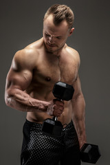 Naklejka premium Awesome muscular guy with dumbell