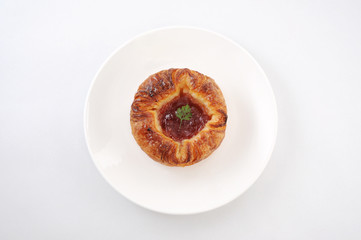 お皿にのせた 苺ジャム デニッシュパン 白背景