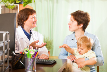 Obraz na płótnie Canvas mother with baby talking with friendly doctor