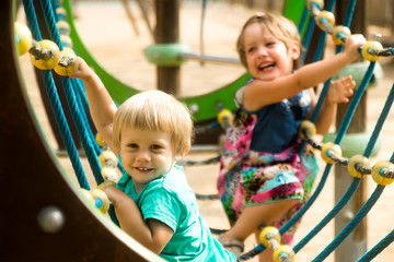 Fototapeta na wymiar Little sisters at playground in park