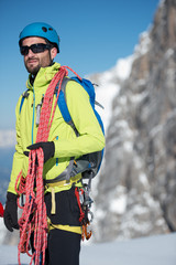 Junger Mann mit Bart und Kletterausr&uuml;stung am schneebedeckten Berg