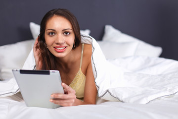 Obraz na płótnie Canvas Women use a tablet pc on the bed