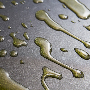 Oil drops on a black pan close up