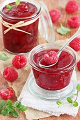 Homemade delicious raspberry jam on a rustic wooden table