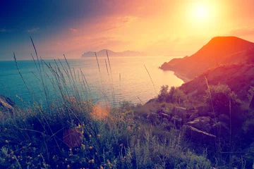 Foto op Plexiglas Prachtige zonsondergang over rotsachtige zeekust © vvvita