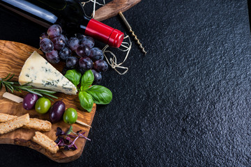 Food background,rustic board with cheese herbs and wine