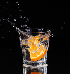 Slice of lemon splashing into a glass 