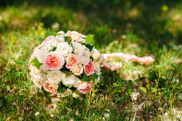 Obraz na płótnie Canvas white wedding bouquet lying on green grass