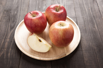 Naklejka na ściany i meble Fresh ripe red apples on dish wooden background