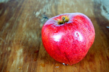 Red apple on wooden board