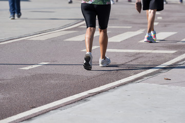 Fototapeta premium Fitness woman legs walking on sidewalk
