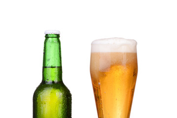 Chilled green bottle with condensate and a glass of beer 