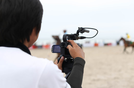 Cameraman working on recording on a beach Polo Tournament