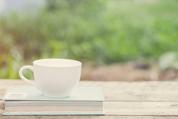 Coffee cup and book on wooden table