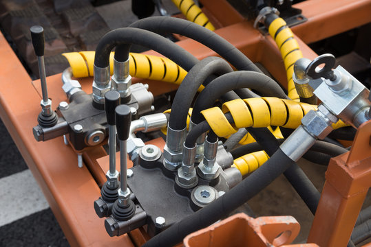 Hydraulic tubes, fittings and levers on control panel 