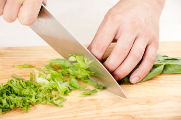Chef cuts lettuce and arugula