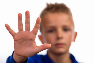 Boy with raised hand making stop gesture