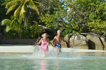 Elderly couple running on the beach 