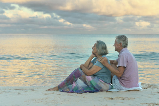 Elderly couple sitting on the shore