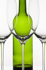 Three empty glasses of wine and green bottle