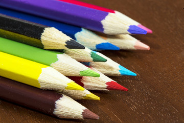 Naklejka premium Multicolored crayons on a wooden background