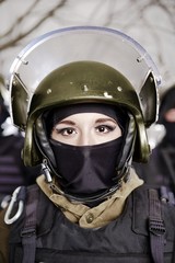 The beautiful young girl in a military uniform and a helmet