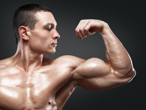 Strong and handsome young bodybuilder demonstrate his muscles an