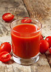 Fresh tomato juice and tomatoes on the table, selective focus