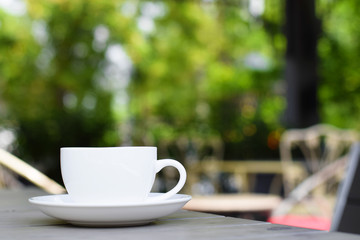Coffee cup on table in garden (vintage background)