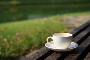 Coffee cup on table in garden (vintage background)