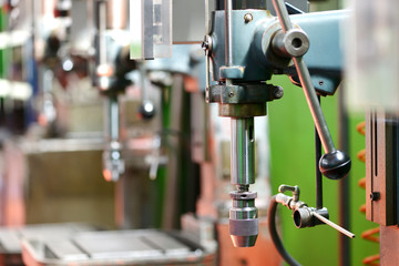 Row of bench drills in a machine workshop