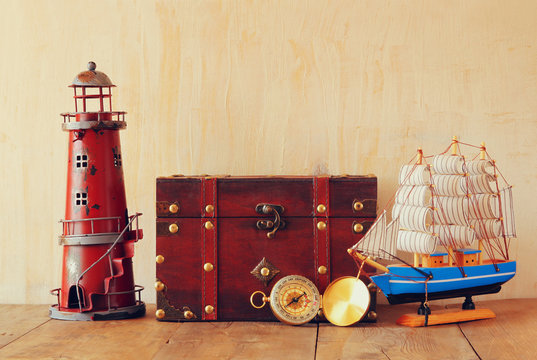 antique compass, vintage lighthouse, wooden boat and old chest