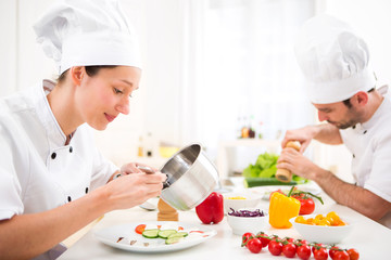 Young attractive professional chef cooking in his kitchen
