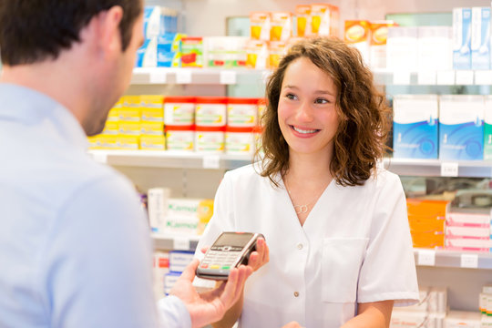 Attractive Pharmacist Taking Healt Insurance Card