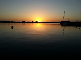 Sole che tramonta dietro il porto