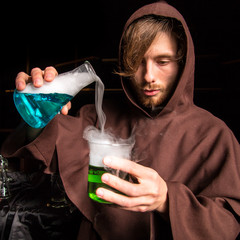 Alchemist in chemical laboratory prepares magical liquids