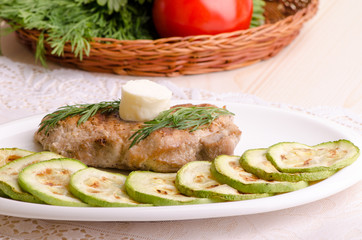 Juicy pork with melting butter and zucchini slices, close-up