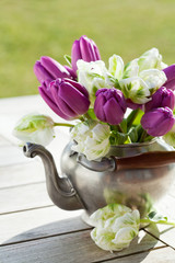 Bouquet of purple and white tulips in tin kettle