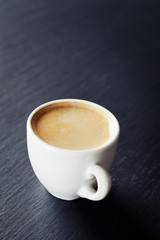 Cup of coffee on black background, toned