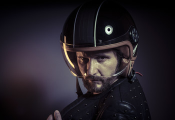 biker with motorcycle helmet and black leather jacket, metal stu