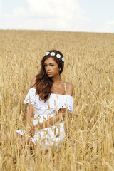 Young woman in a wheat golden field